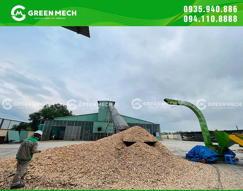 Đống dăm gỗ cạnh máy băm tại khu vực sản xuất
